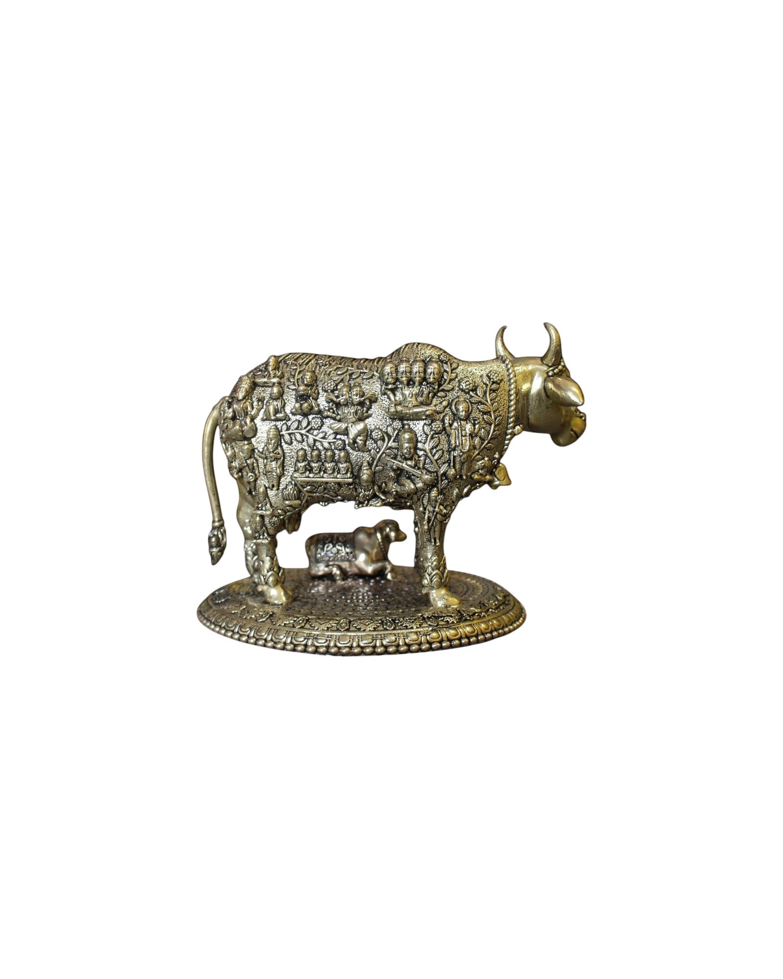 Rigvedaa brass Kamdhenu cow and calf idol with engraved gods, symbolizing prosperity and divine blessings.