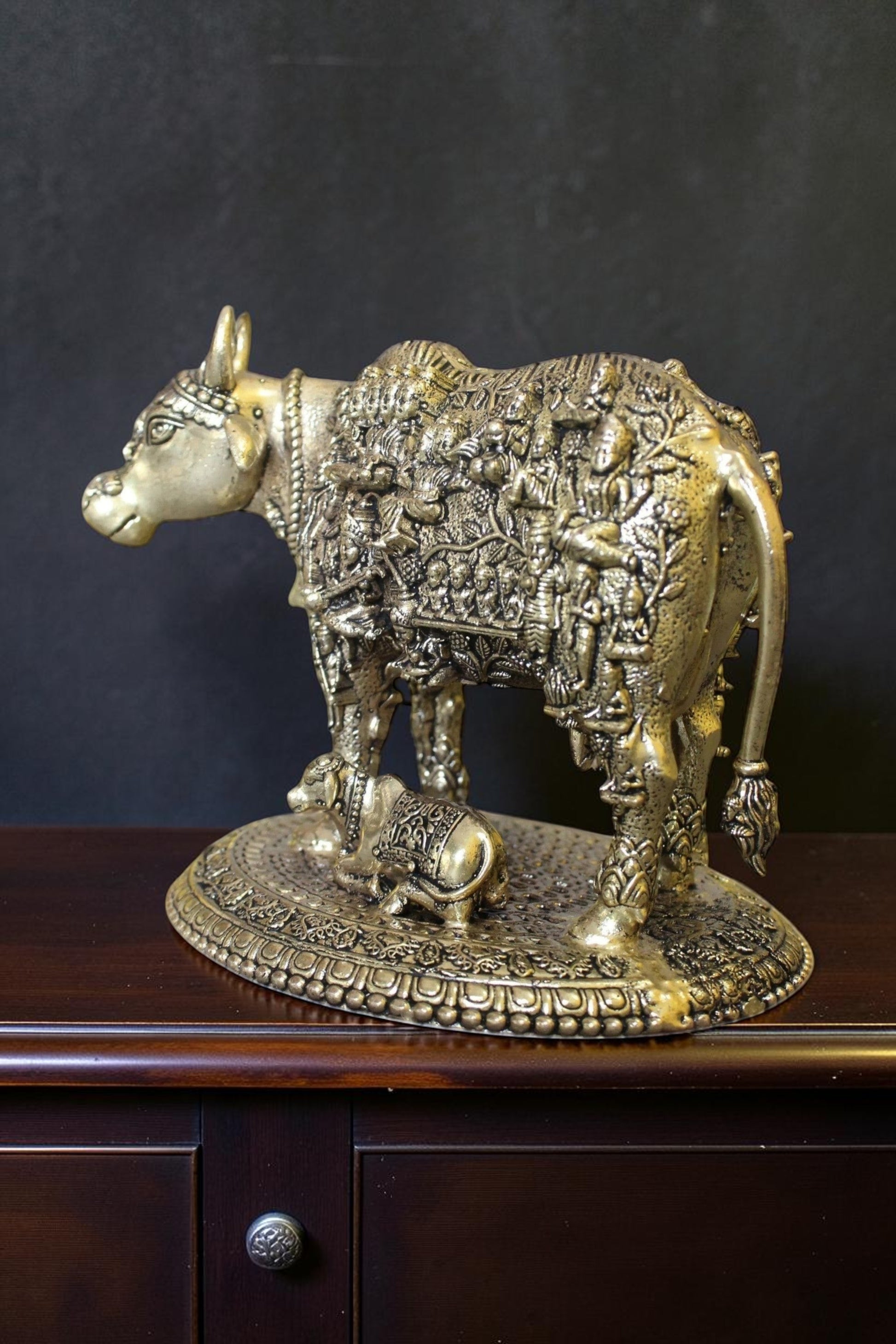 Rigvedaa™ brass Kamdhenu cow and calf idol with intricate engravings of Hindu gods, symbolizing prosperity and divine blessings.