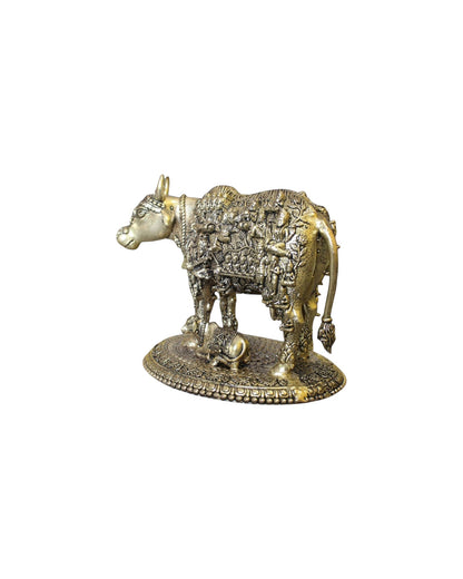 Rigvedaa™ brass Kamdhenu cow and calf idol with intricate engravings of Hindu gods, symbolizing prosperity and divine blessings.