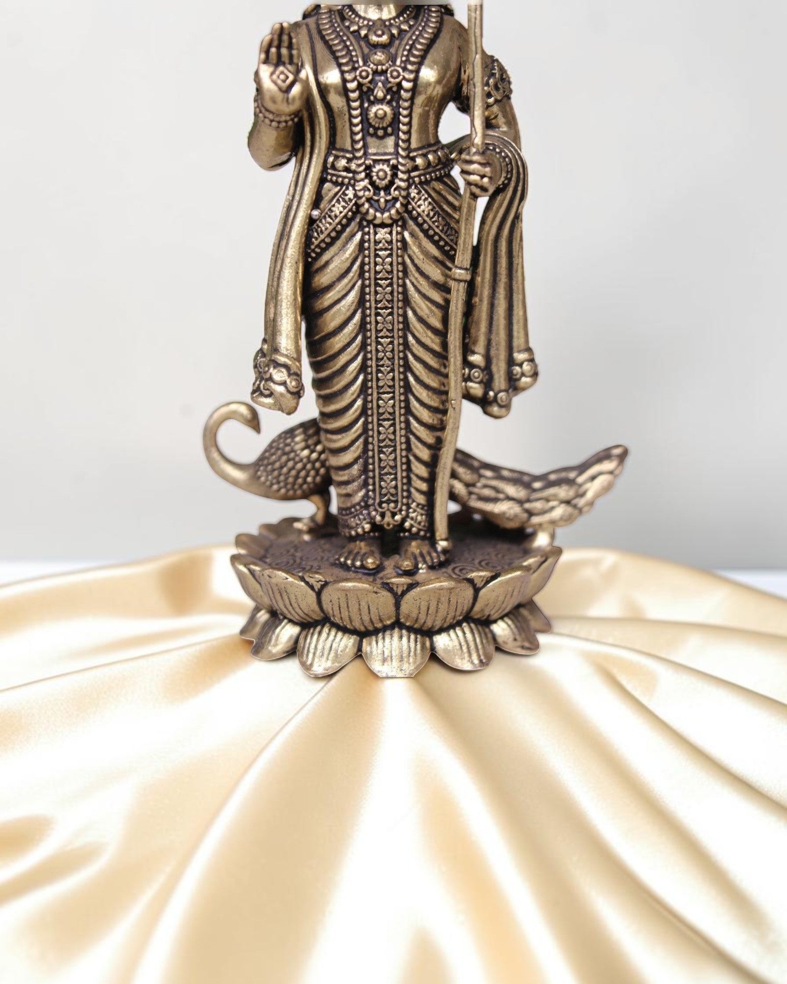 Rigvedaa brass idol of Lord Kartikeya holding a spear, standing on a lotus with peacocks. Ideal for pooja rooms.