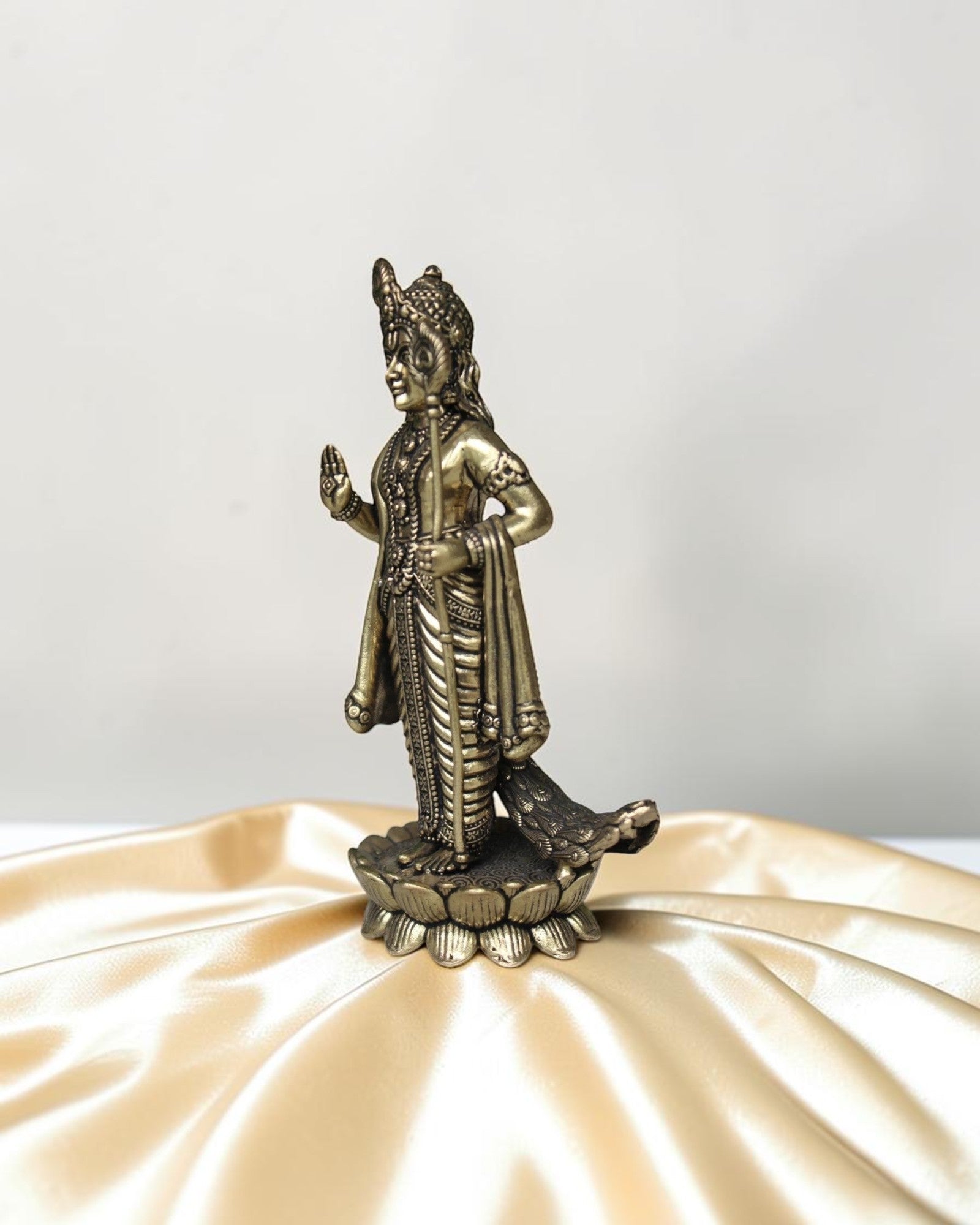 Rigvedaa brass idol of Lord Kartikeya standing on a lotus, holding a spear, with peacock feather details.