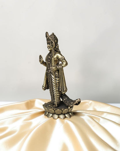 Rigvedaa brass idol of Lord Kartikeya standing on a lotus, holding a spear, with peacock feather details.