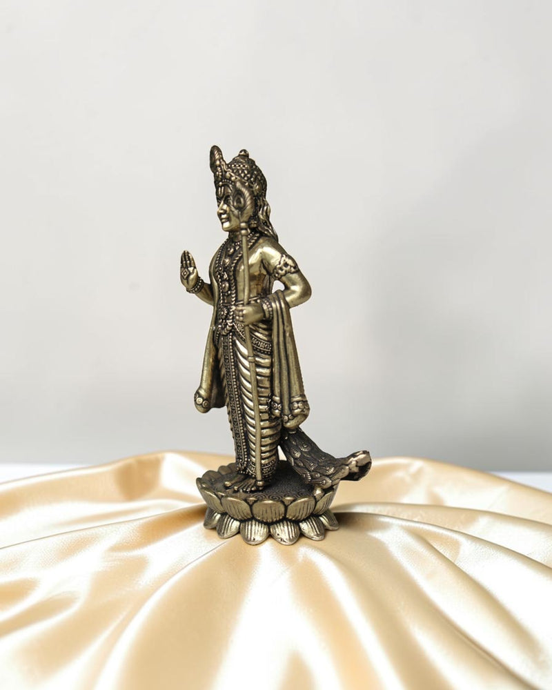 Rigvedaa brass idol of Lord Kartikeya standing on a lotus, holding a spear, with peacock feather details.