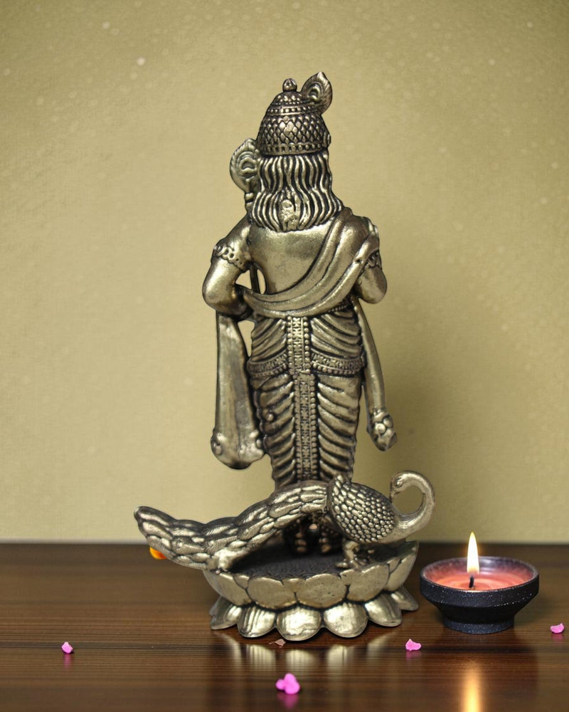 Rigvedaa brass idol of Lord Kartikeya holding a spear, with a peacock at his feet. Detailed traditional finish.