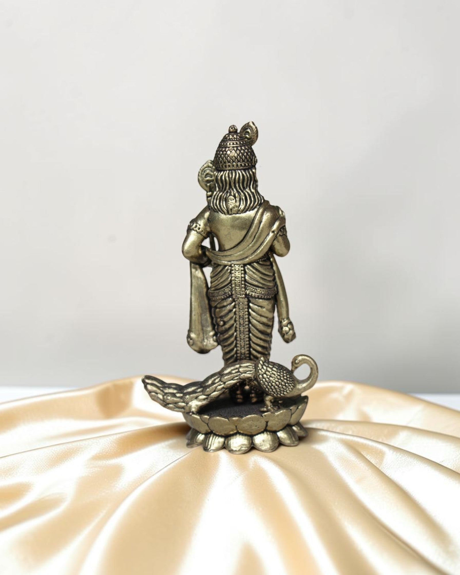 Rigvedaa brass idol of Lord Kartikeya holding a spear, with a peacock at his feet. Detailed traditional finish.