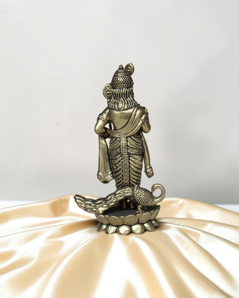 Rigvedaa brass idol of Lord Kartikeya holding a spear, with a peacock at his feet. Detailed traditional finish.