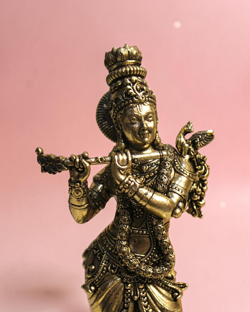Rigvedaa

Handcrafted brass statue of Lord Krishna playing the flute, detailed traditional attire, peacock feather crown, golden patina.