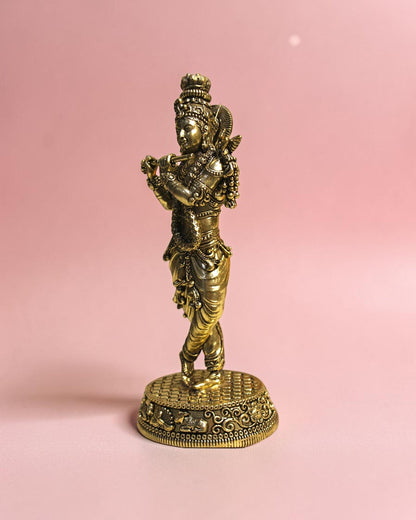 Rigvedaa™ Handcrafted brass statue of Lord Krishna playing the flute, detailed traditional attire, on a decorative base.
