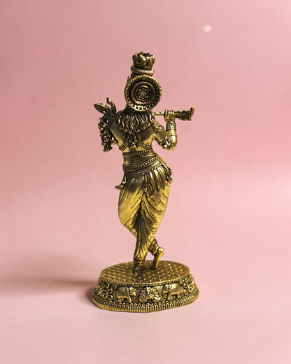 Rigvedaa
™ Handcrafted brass statue of Lord Krishna playing the flute, detailed traditional attire, on a decorative base.