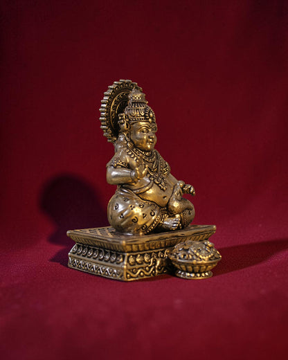 Rigvedaa	exttrademark
 brass Kuber idol sitting on a chowki, holding a money pot and mongoose. Golden patina.