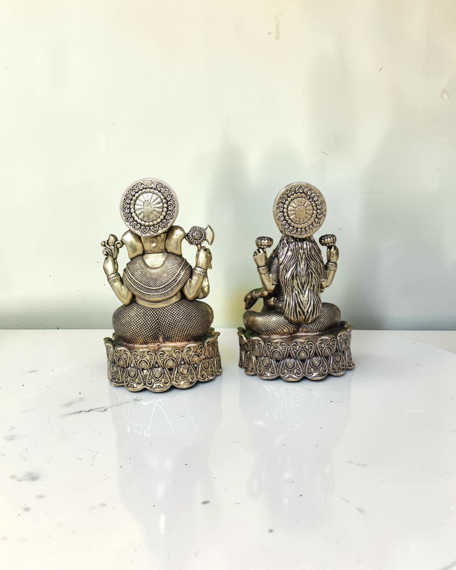 Rigvedaa brass Lakshmi Ganesh idol on lotus base, golden finish, intricate detailing, with yellow flowers.
