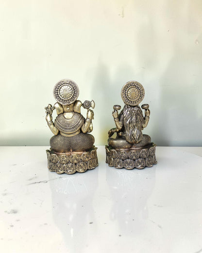 Rigvedaa brass Lakshmi Ganesh idol on lotus base, golden finish, intricate detailing, with yellow flowers.