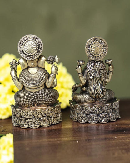 Rigvedaa brass Lakshmi Ganesh idol on lotus base, golden finish, intricate detailing, with yellow flowers.