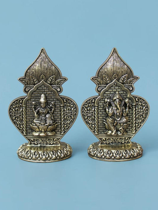 Rigvedaa™ brass Lakshmi and Ganesha idol set featuring ornate Kalash arch frames with an antique gold patina finish.