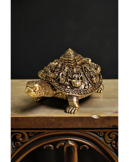 Rigvedaa™ golden brass tortoise figurine with intricate Ashta Lakshmi figures and Shree Yantra engraving on its shell, representing prosperity and good fortune.