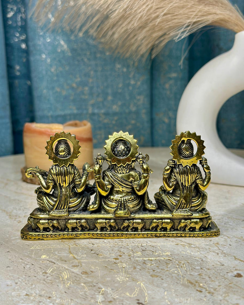 Rigvedaa™ Brass Laxmi Ganesh Saraswati idol set, golden patina, intricate details, traditional Indian art for home or office altar.