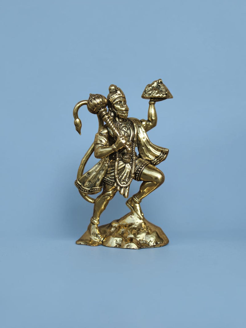 Rigvedaa™ brass Lord Hanuman idol holding a mountain and mace with a polished golden finish on a blue background
