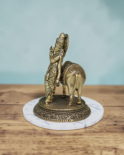 Rigvedaa™ Brass Lord Krishna with Cow Vastu Statue, 5-inch golden patina, intricate detailing, spiritual decor.