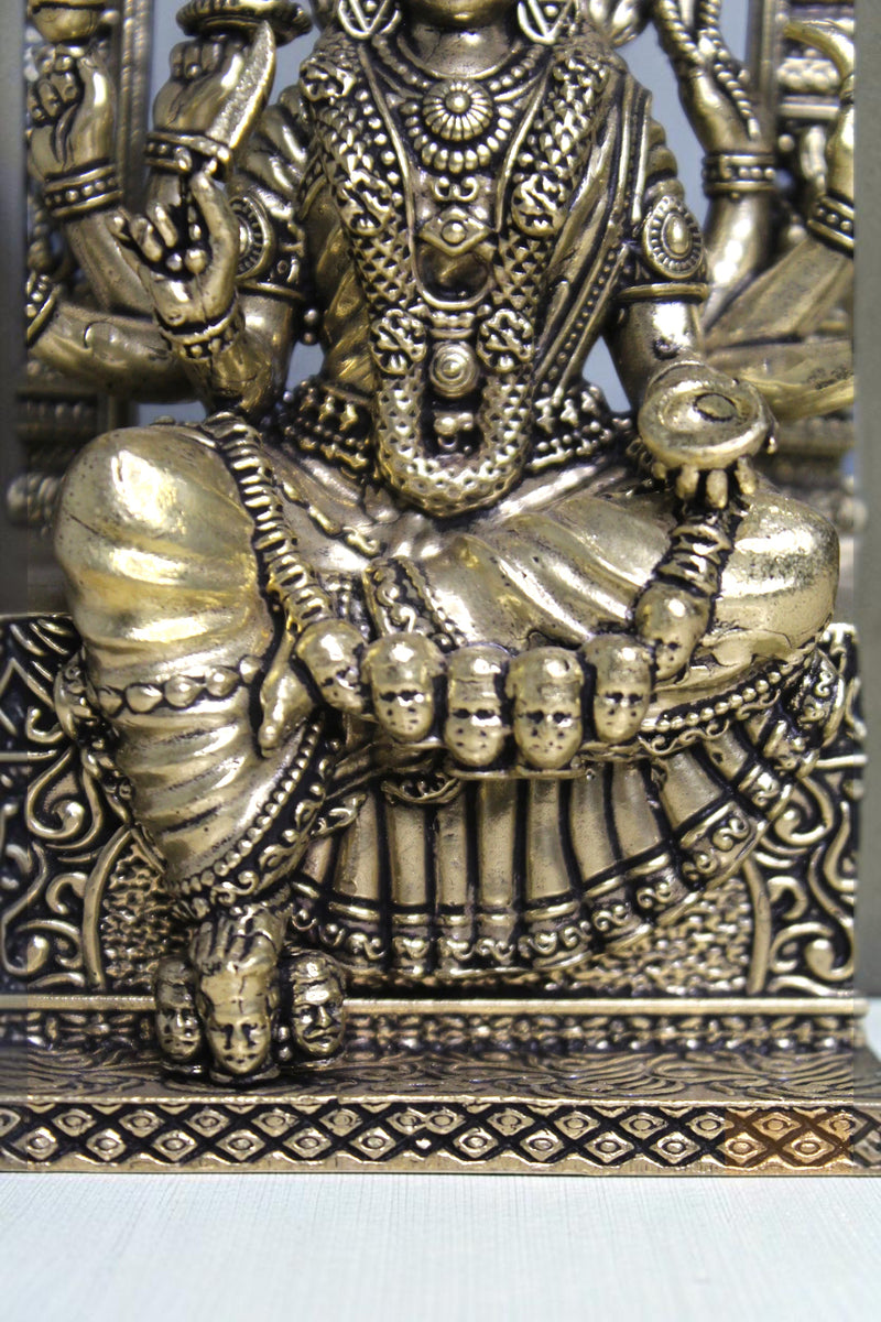 Rigvedaa™ 6-inch brass idol of Goddess Mariamman seated, adorned with jewelry and multiple arms. Features intricate details and a golden finish.