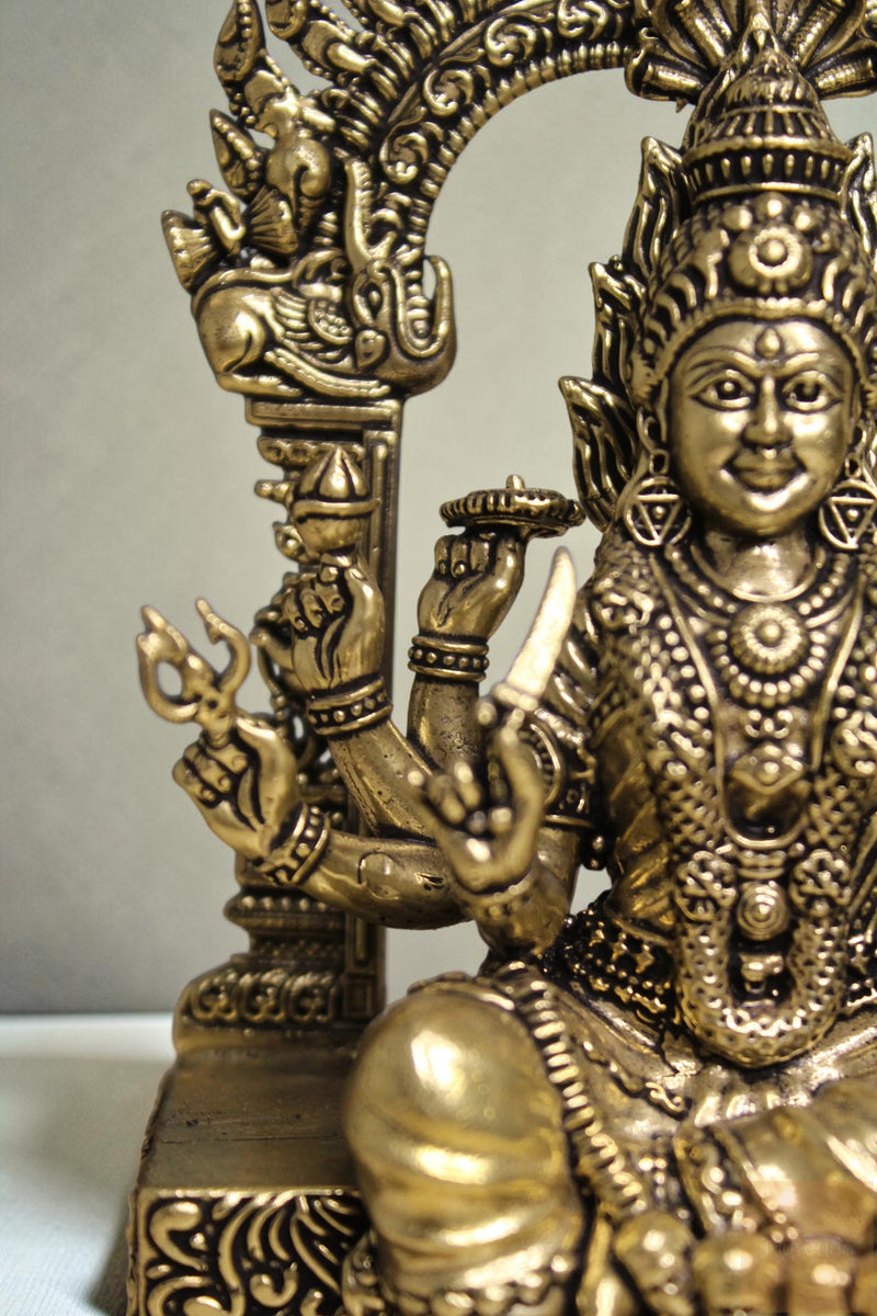 Rigvedaa™ brass idol of Goddess Mariamman, 6-inch, seated, holding trident and knife, adorned with jewelry.