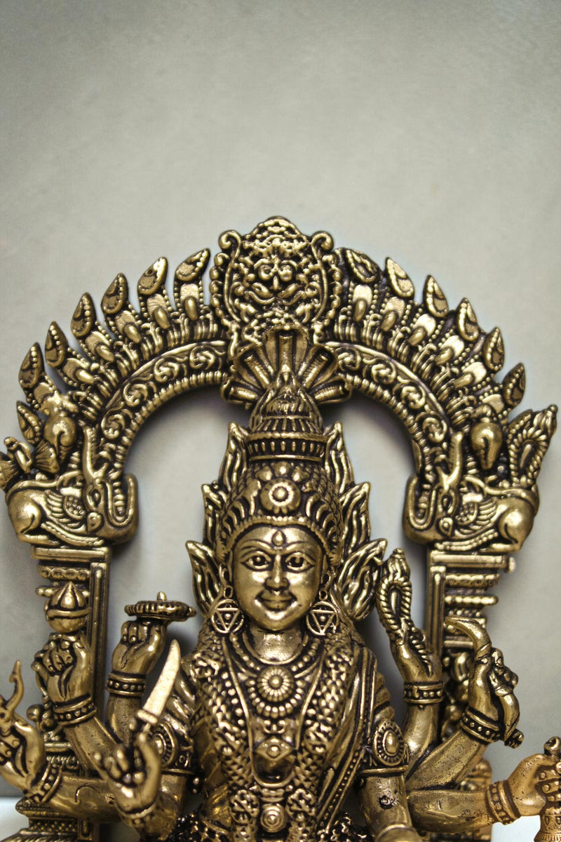 Rigvedaa™ brass idol of Goddess Mariamman, 6-inch, seated, holding weapons, adorned with jewelry and a serpent crown.