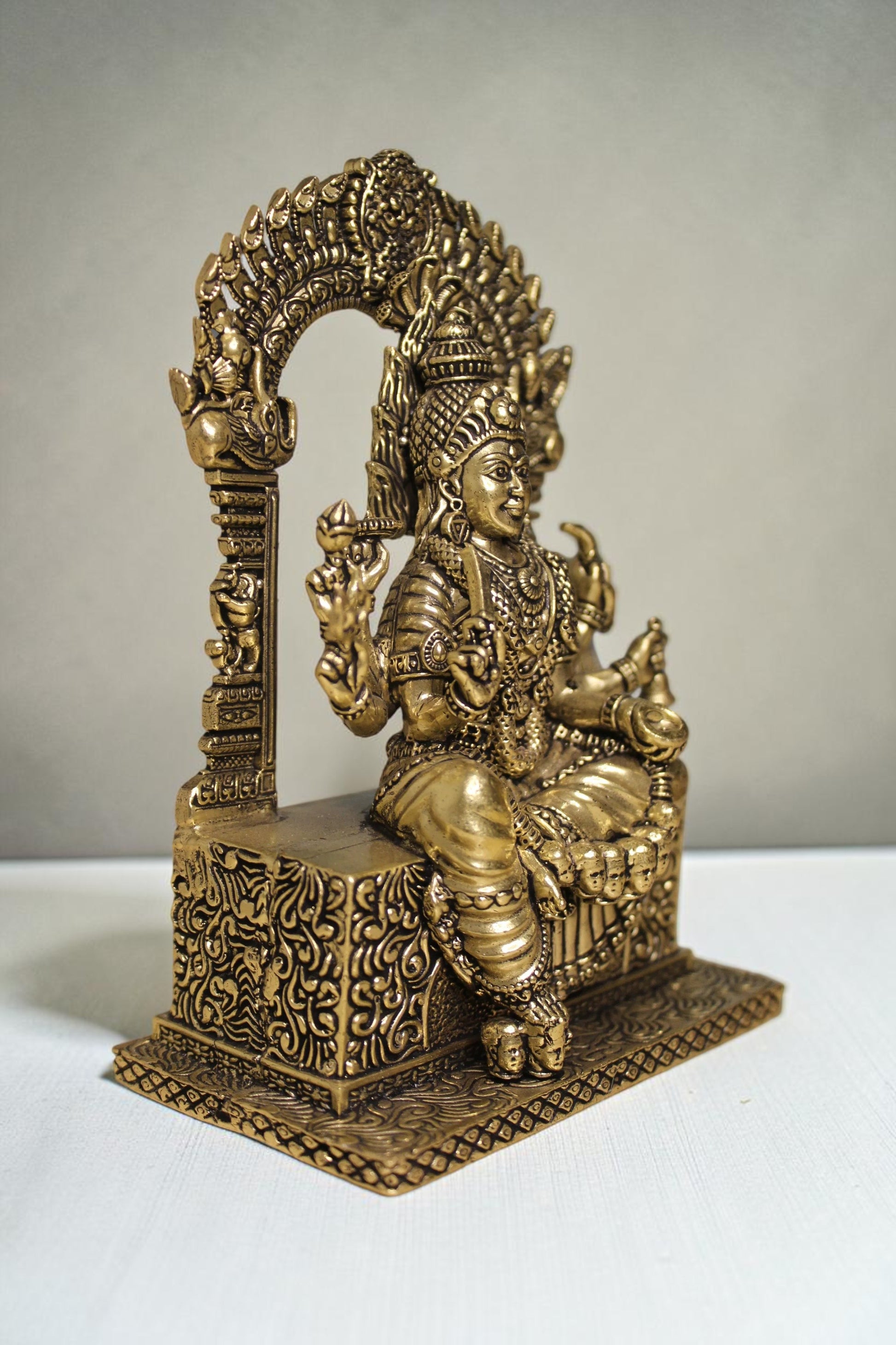Rigvedaa™ brass idol of Goddess Mariamman seated with ornate headdress and intricate details, 6 inches tall.