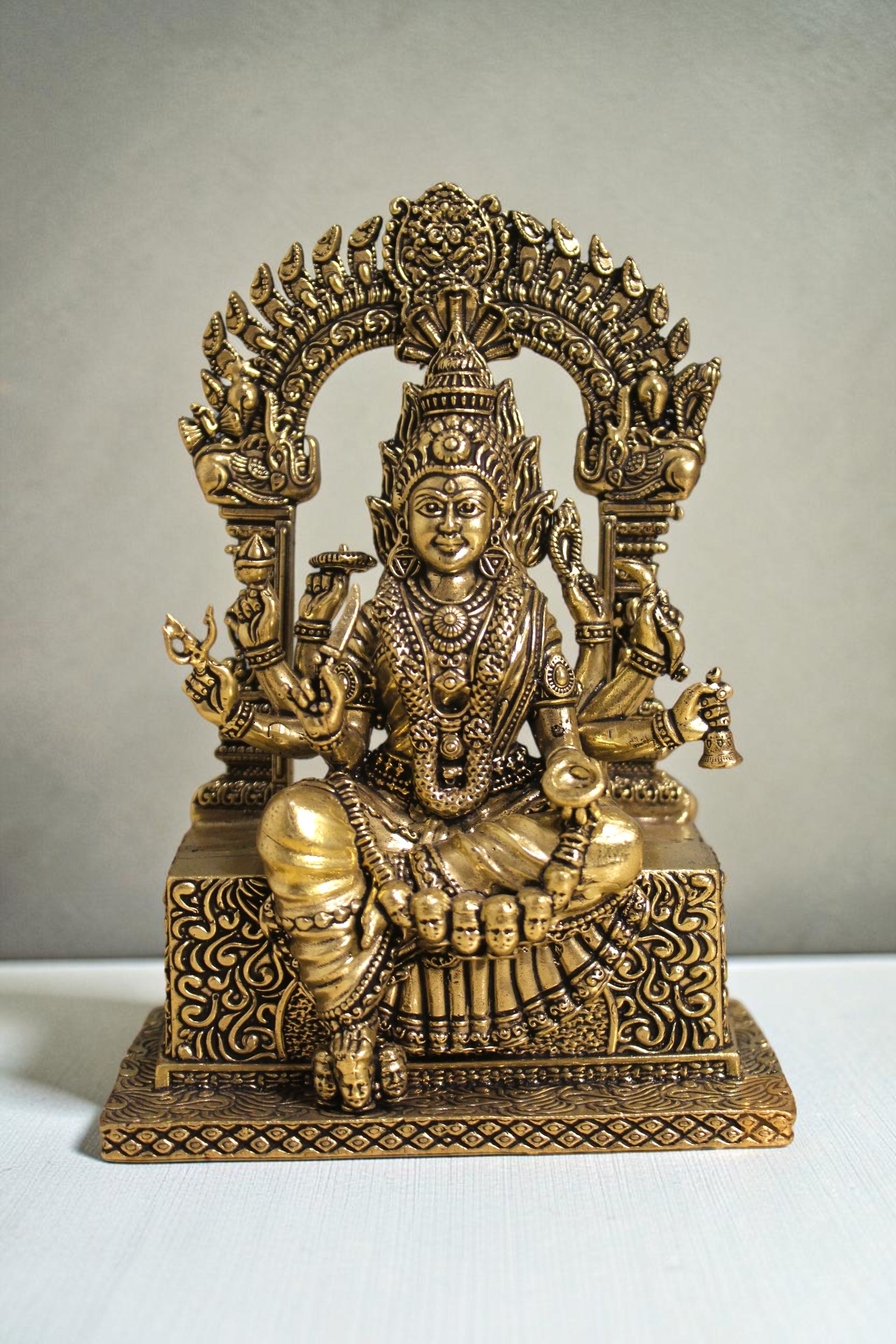 Rigvedaa™ brass idol of Goddess Mariamman seated, adorned with jewelry and multiple arms, 6 inches tall.