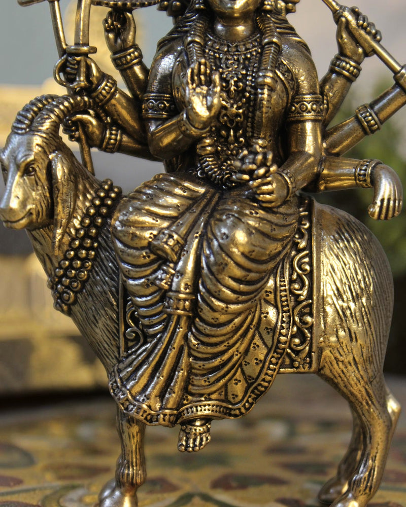 Rigvedaa	raderass Meldi Maa statue on goat, folk goddess sculpture with multiple arms and intricate details, golden patina.