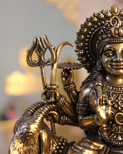 Rigvedaa™ Brass Meldi Maa statue on goat, folk goddess sculpture with trident, golden patina, intricate details.