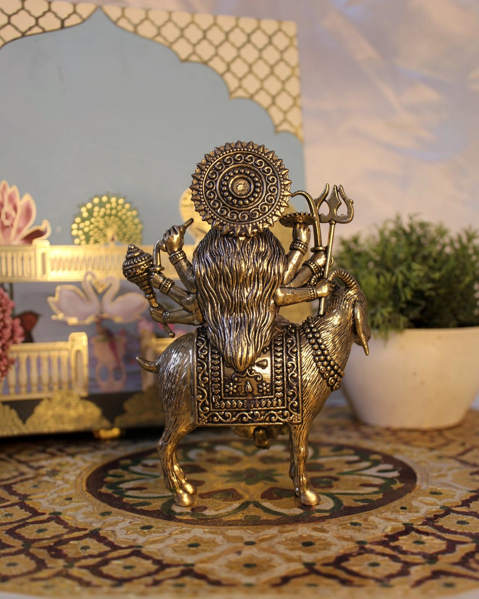 Rigvedaa Brass Meldi Maa statue on goat, protective folk goddess sculpture with multiple arms and weapons, golden patina.