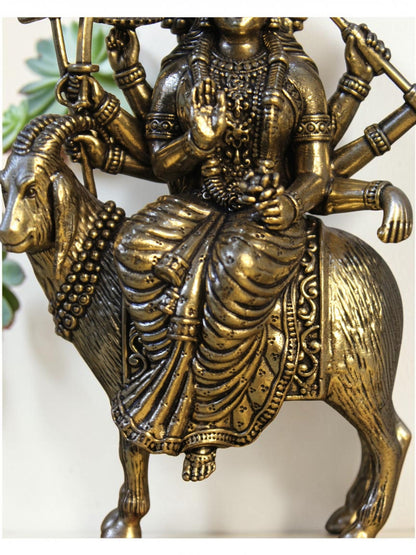 Rigvedaa™ brass Meldi Maa statue featuring the multi-armed goddess seated on a goat with a golden patina finish.