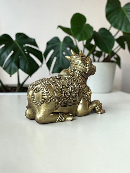 Rigvedaa™ handcrafted brass Nandi idol featuring intricate floral engravings and beadwork on a white surface.