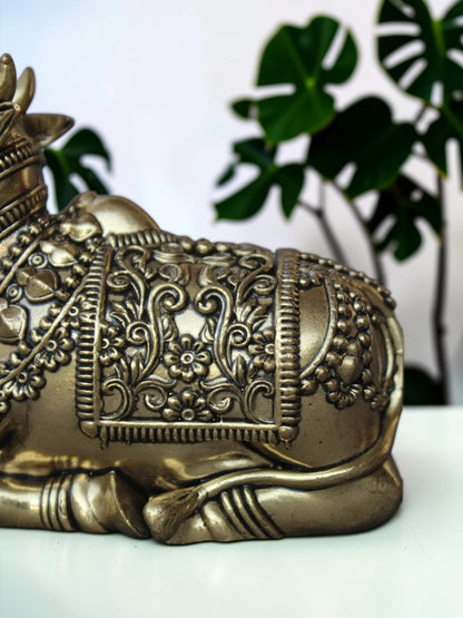 Rigvedaa™ handcrafted brass Nandi idol featuring intricate floral engravings and beadwork on a polished golden finish.