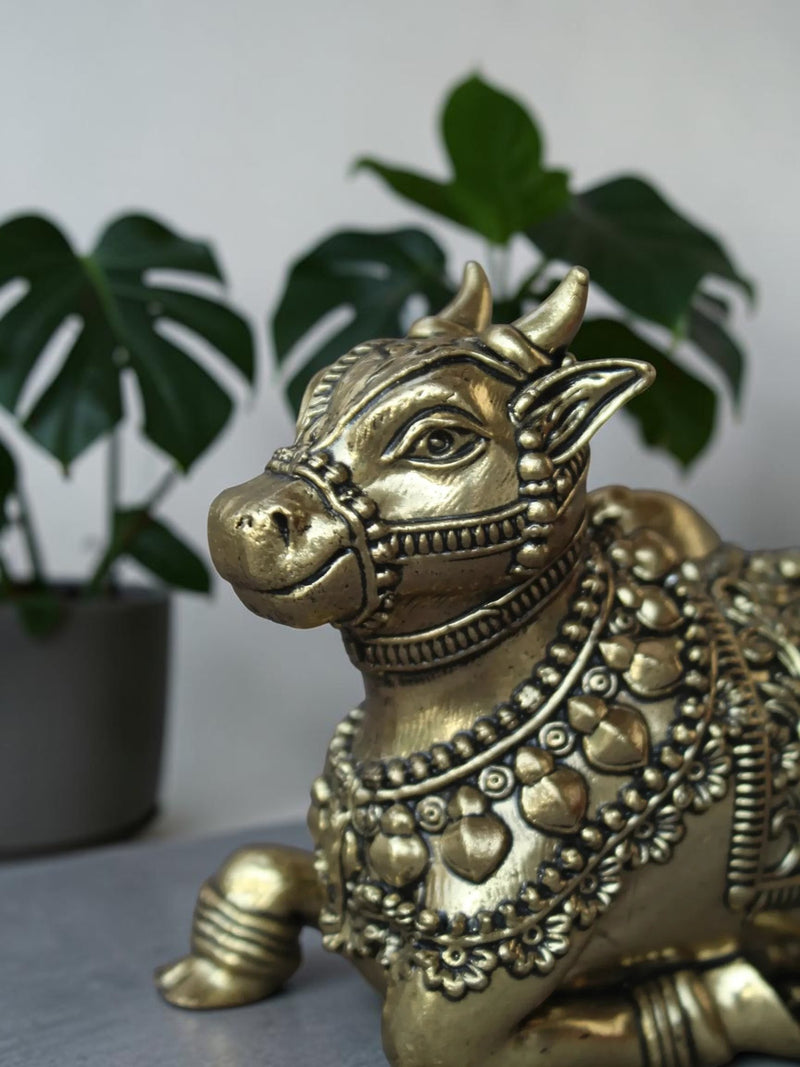 Rigvedaa™ handcrafted brass Nandi idol featuring intricate floral engravings and beadwork in a polished golden finish.