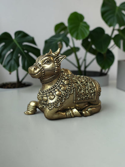 Rigvedaa™ handcrafted brass Nandi idol featuring intricate floral engravings and beadwork in a polished golden finish.
