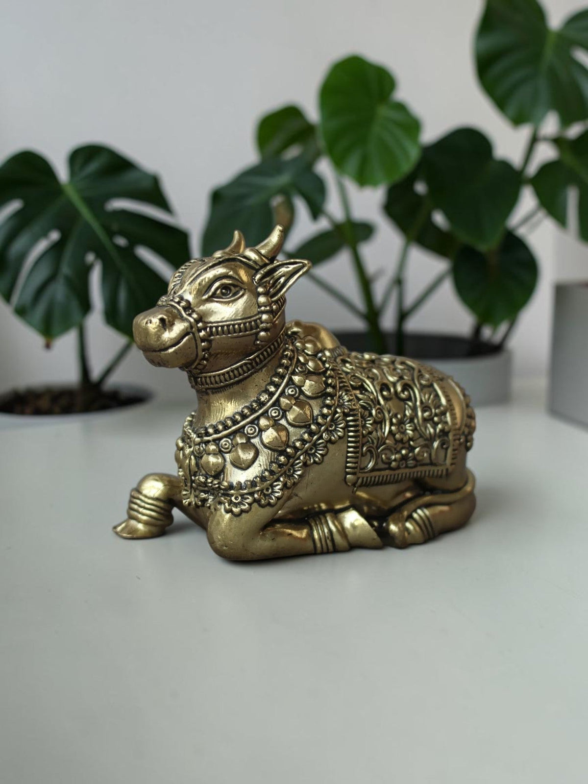 Rigvedaa™ handcrafted brass Nandi idol featuring intricate floral engravings and beadwork in a polished golden finish.