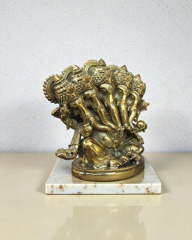 Rigvedaa™ Brass Panchmukhi Ganesha statue with five faces, intricate details, seated on a marble base. Golden patina.