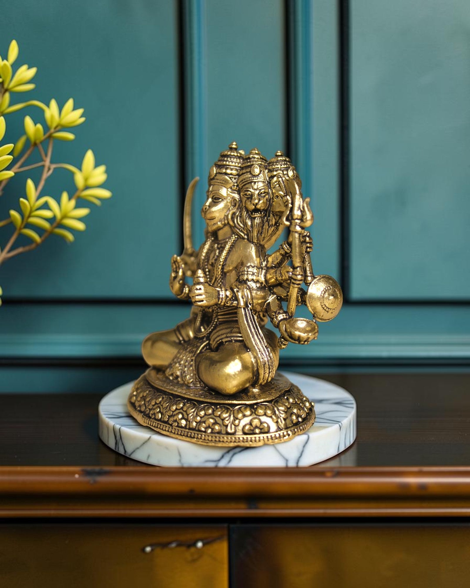 Rigvedaa™ Brass Sitting Panchmukhi Hanuman Statue with five faces, holding weapons, on a marble base.