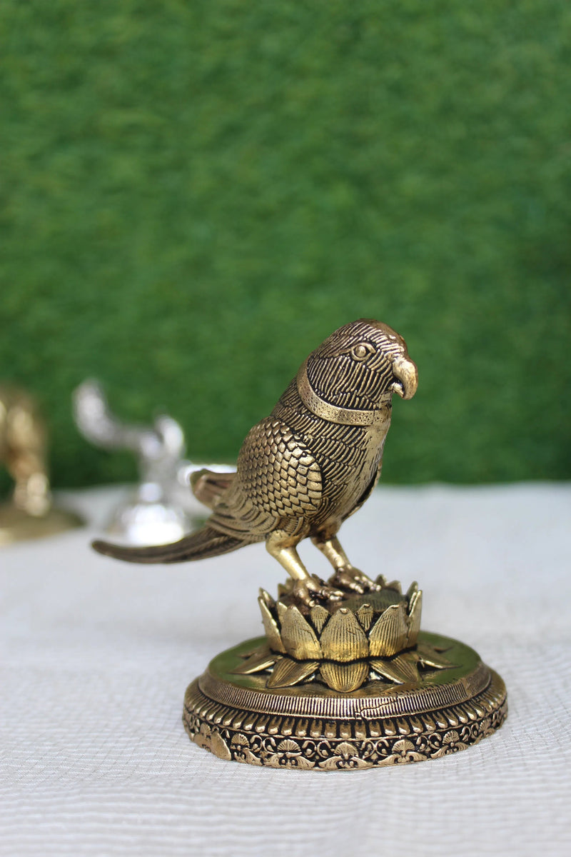 Rigvedaa™ 3-inch brass parrot figurine intricately carved with detailed feathers, perched on a lotus base. Polished brass finish.