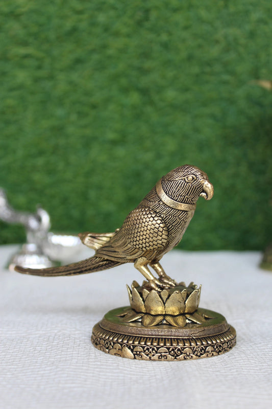 Rigvedaa™ 3-inch brass parrot figurine perched on a lotus base, featuring intricate feather detailing and a polished gold finish.