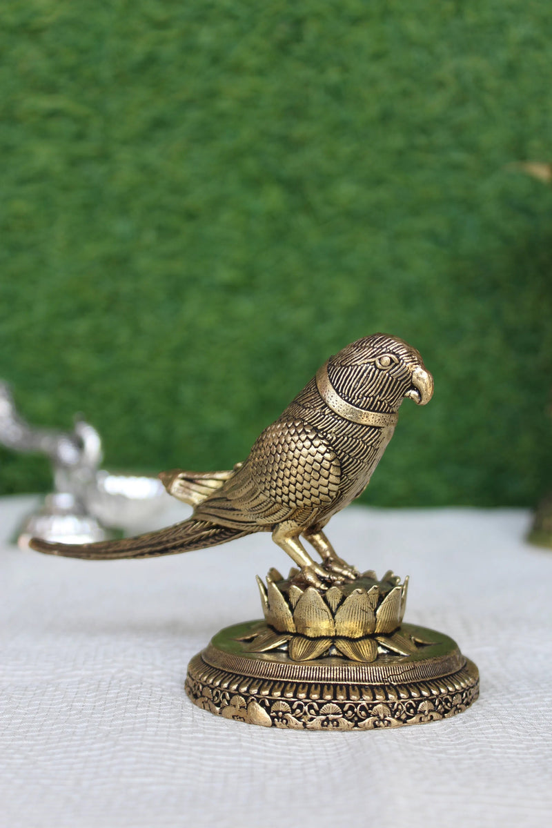 Rigvedaa™ 3-inch brass parrot figurine perched on a lotus base, featuring intricate feather detailing and a polished gold finish.