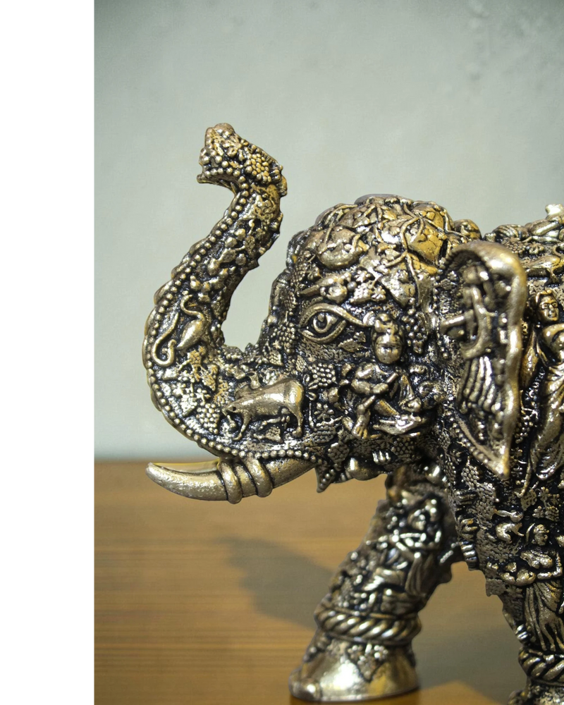 Rigvedaa brass elephant statue with intricate Radha Krishna murals and golden finish. Symbolizes wisdom and divine love.