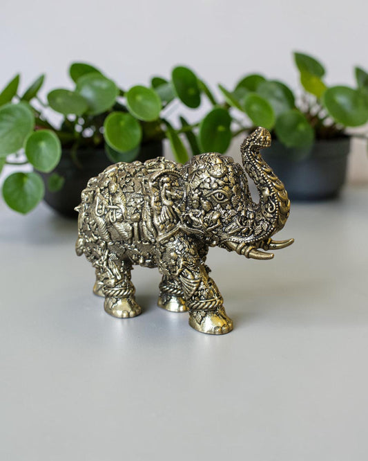 Rigvedaa™ brass elephant statue with intricate hand-carved Radha Krishna murals and a radiant golden antique finish.