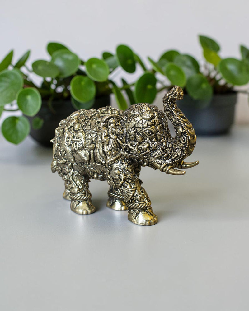 Rigvedaa™ brass elephant statue with intricate hand-carved Radha Krishna murals and a radiant golden antique finish.