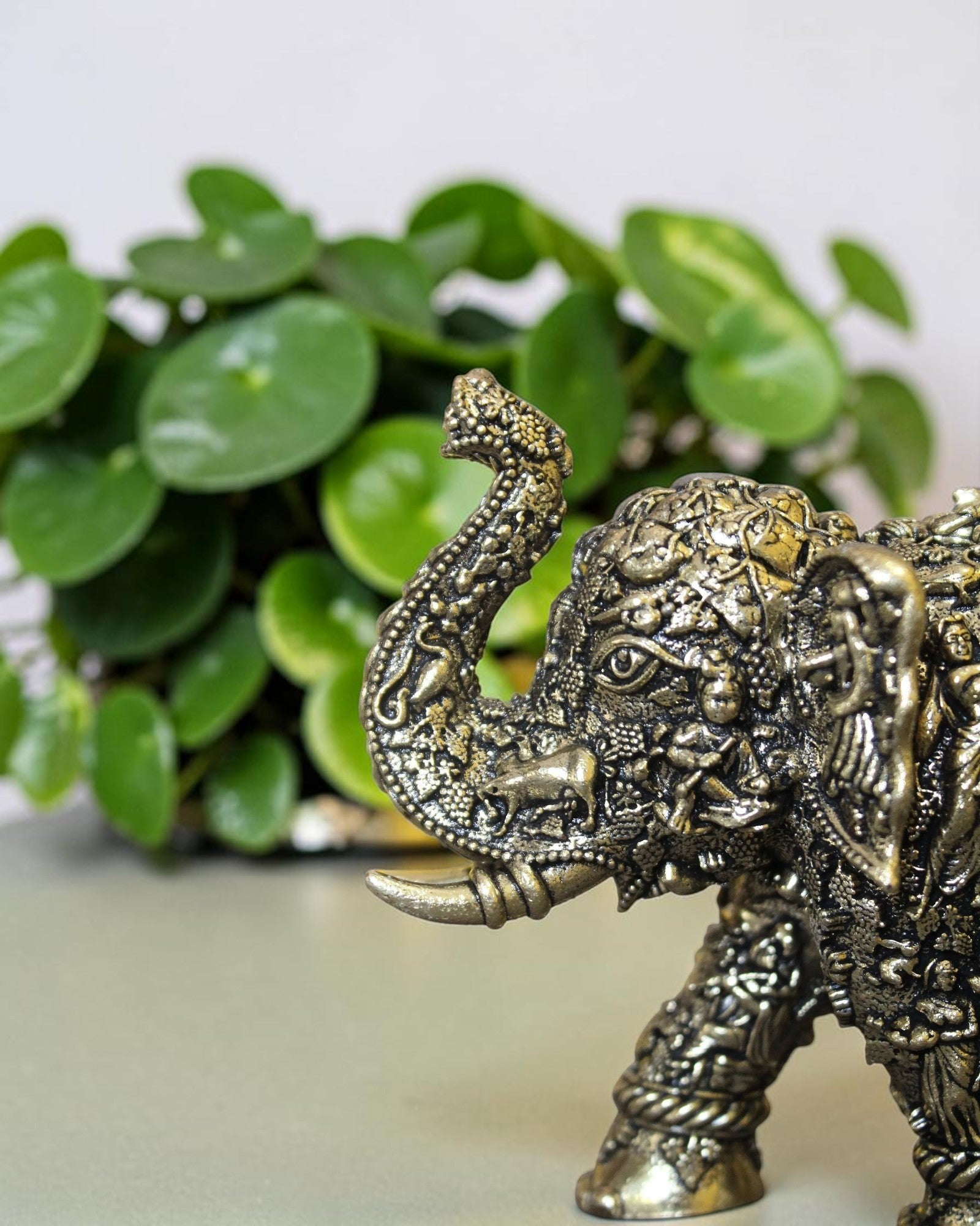 Rigvedaa™ brass elephant statue with intricate hand-carved Radha Krishna murals and a radiant golden antique finish.