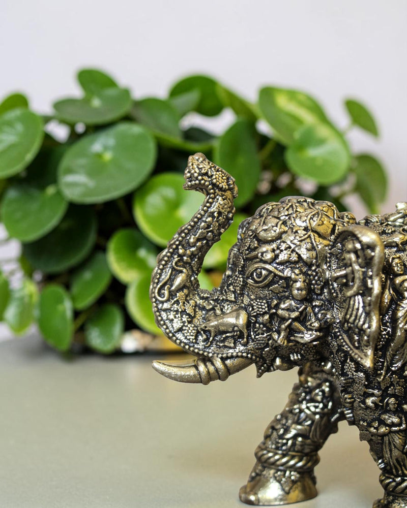 Rigvedaa™ brass elephant statue with intricate hand-carved Radha Krishna murals and a radiant golden antique finish.