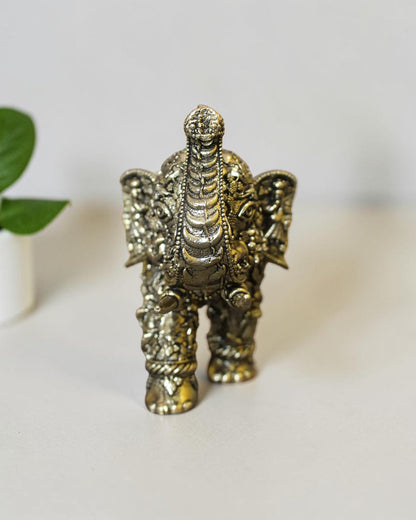 Rigvedaa™ brass elephant statue featuring intricate hand-carved Radha Krishna murals and a polished golden patina.