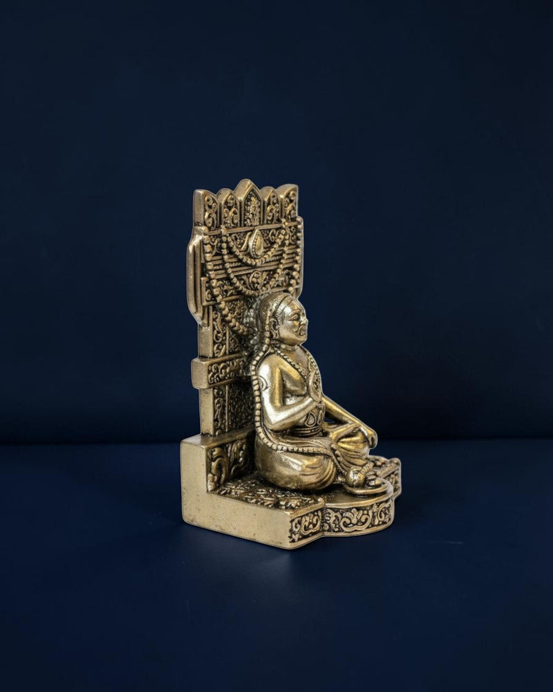 Rigvedaa™ brass Guru Raghavendra Swamy idol in a traditional seated posture with intricate carvings, side view.