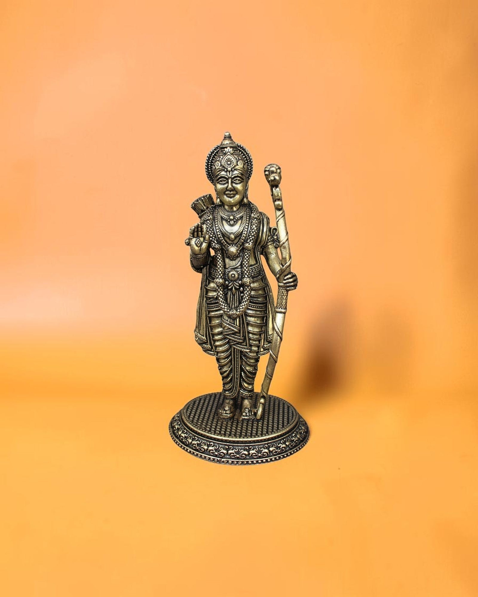 Rigvedaa™ Brass Ram Darbar statue set featuring Lord Rama with bow, Mata Sita, Lakshmana, and Hanuman on a decorative base. Golden patina finish.