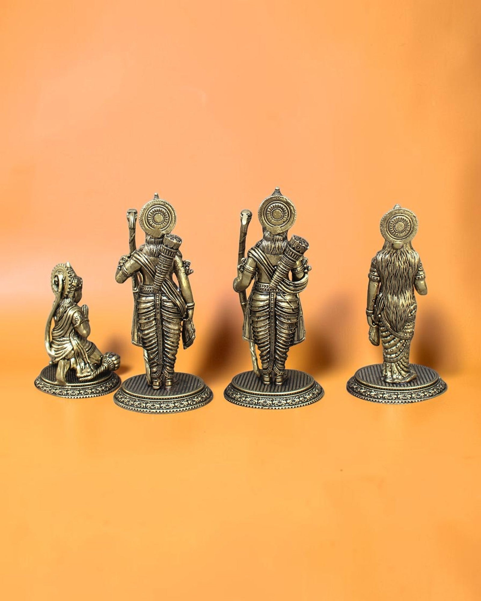 Rigvedaa™ Brass Ram Darbar statue set featuring Rama, Sita, Lakshmana, and Hanuman in traditional attire with intricate detailing. Rama holds a bow, Sita radiates grace, Lakshmana stands beside them, and Hanuman kneels in devotion.